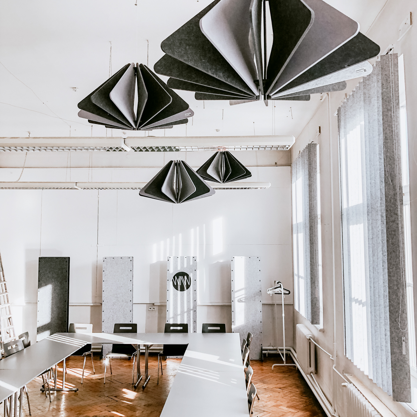 Lecture room at the Academy of Fine Arts in Krakow. Four acoustic ceiling rafts hanging from the ceiling. Sound absorbing acoustic blinds are hanging on two windows.